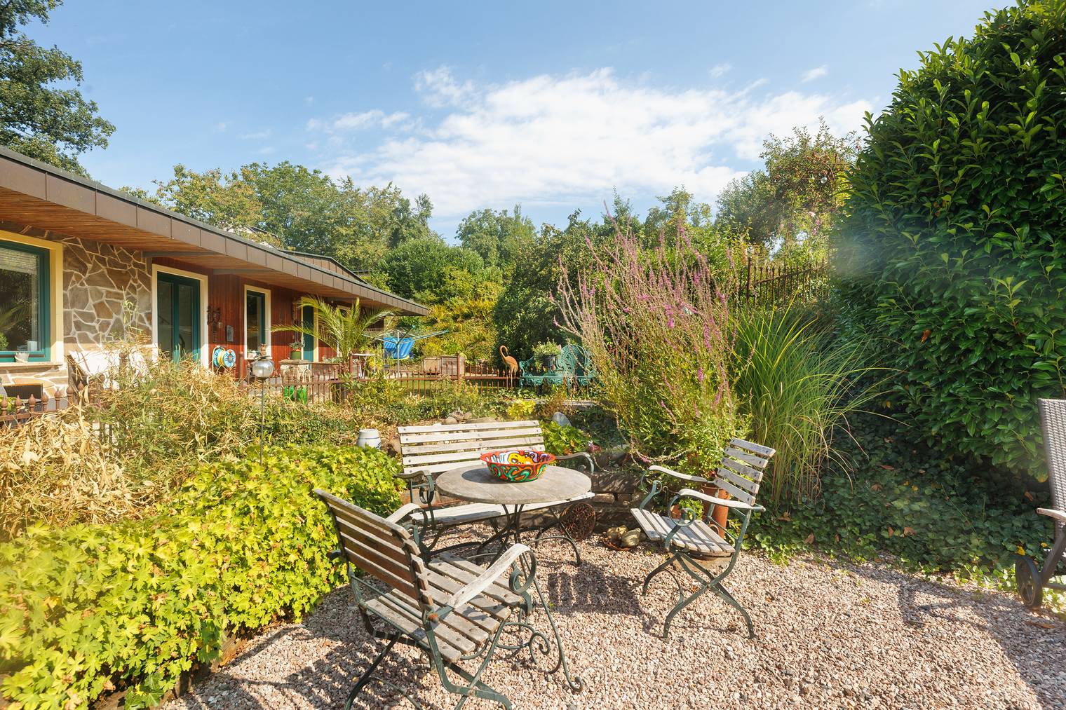 Private Südterrasse mit Gartenmöbeln im Grünen